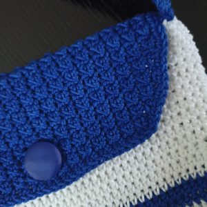 Χειροποίητη πλεκτή παιδική τσάντα χιαστί σε μπλε ρουά και λευκό.