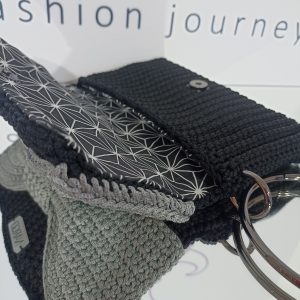 Χειροποίητη πλεκτή μαύρη τσάντα φάκελος με γκρι φιόγκο και μαύρα μεταλλικά στοιχεία.