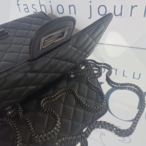 Γυναικεία καπιτονέ τσάντα ώμου και χιαστί σε μαύρο χρώμα με μαύρα μεταλλικά στοιχεία.