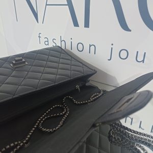 Γυναικεία καπιτονέ τσάντα ώμου και χιαστί σε μαύρο χρώμα με μαύρα μεταλλικά στοιχεία.