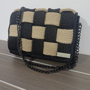 Χειροποίητη πλεκτή τσάντα ώμου και χιαστί σε μαύρο με μπεζ και μαύρα μεταλλικά στοιχεία.