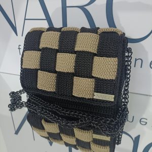 Χειροποίητη πλεκτή τσάντα ώμου και χιαστί σε μαύρο με μπεζ και μαύρα μεταλλικά στοιχεία.