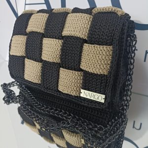 Χειροποίητη πλεκτή τσάντα ώμου και χιαστί σε μαύρο με μπεζ και μαύρα μεταλλικά στοιχεία.